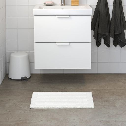 White IKEA bath mat placed on a bathroom floor, featuring a soft and absorbent texture and a non-slip bottom for secure footing 70482967