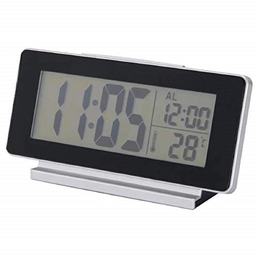 A digital alarm clock with a large snooze button 10422542