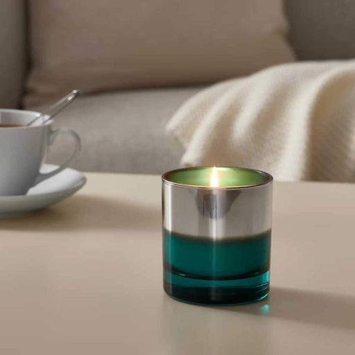 A clear glass jar containing a scented candle, with an inviting fragrance and a calming effect on the senses.