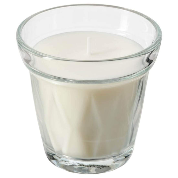 A unscented candle in an elegant glass holder, perfect for creating a warm and inviting atmosphere in any room.