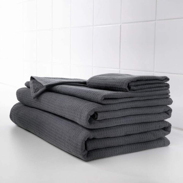 An anthracite hand towel from the Ikea 6 Piece Combo Set, hanging on a silver towel bar next to a white sink.