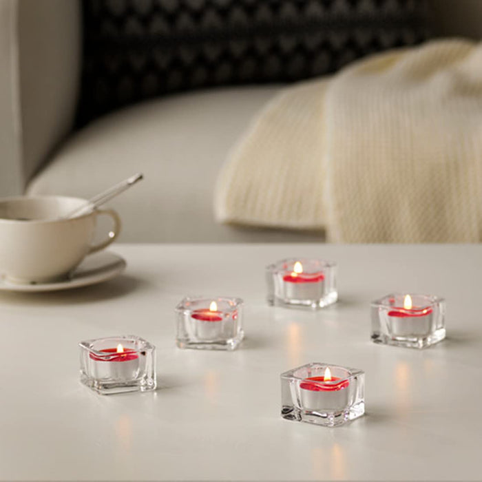 A cozy living room with several lit IKEA Scented Tealight Gingerbread candles, creating a warm and inviting atmosphere.