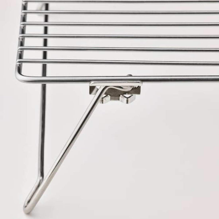 A baking cooling rack made of stainless steel wire with a flat surface and four feet.