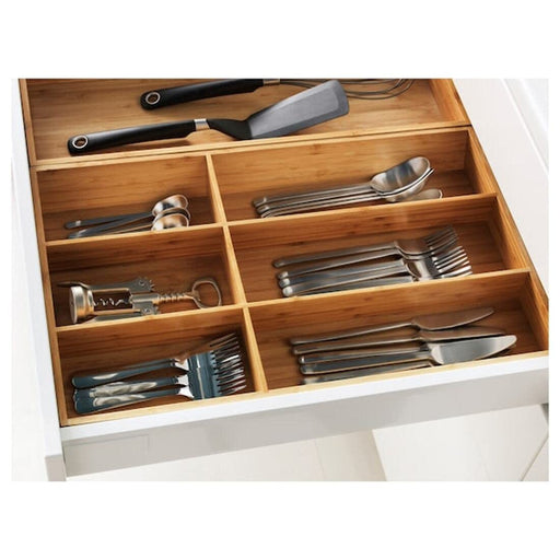 An eco-friendly cutlery tray made of bamboo, featuring compartments of various sizes for storing forks, knives, spoons, and other utensils.
