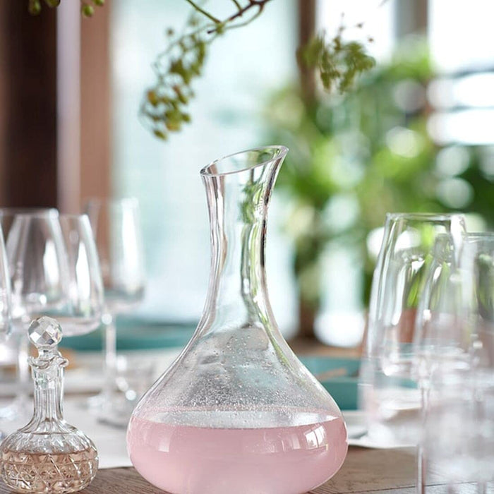 A clear glass carafe from IKEA, ideal for serving water, juice, or wine at your next gathering.