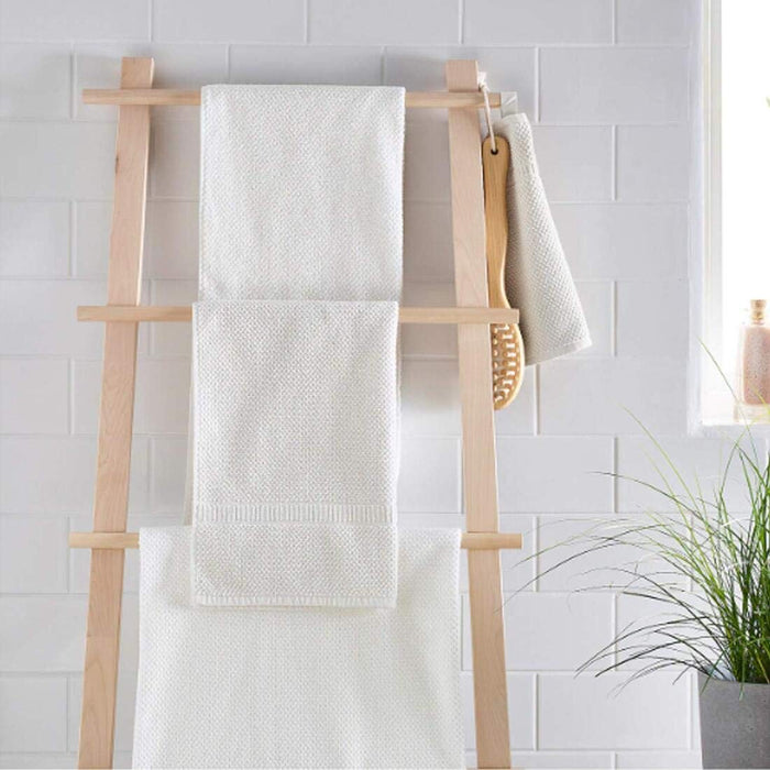 A patterned white hand towel hanging from a towel rack in a stylish bathroom 80313224