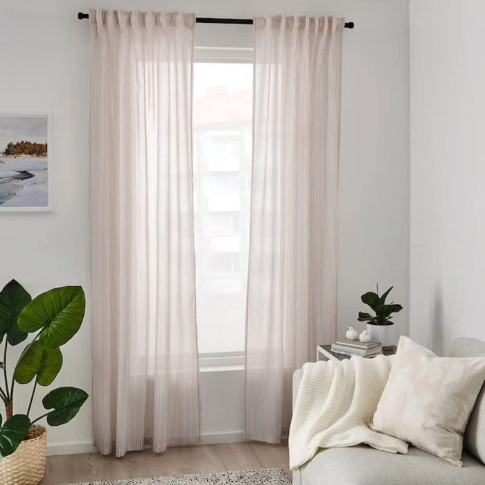 A bedroom featuring blackout curtains from IKEA, shown closed to block out all light for a good night's sleep. The curtains are available in a range of colors to match any decor.