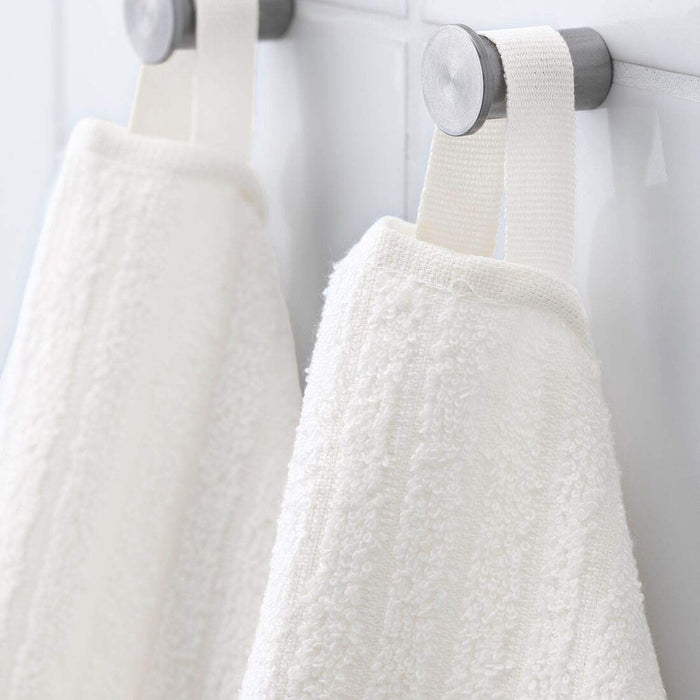 A close-up image of a folded White hand towel with a textured pattern 00439430