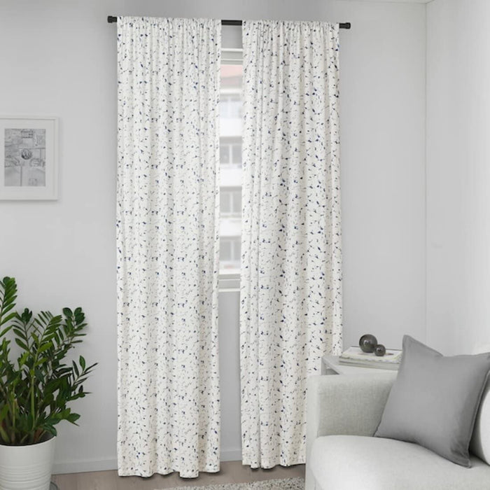 Light filtering beige IKEA Curtains draped over a curtain rod."
