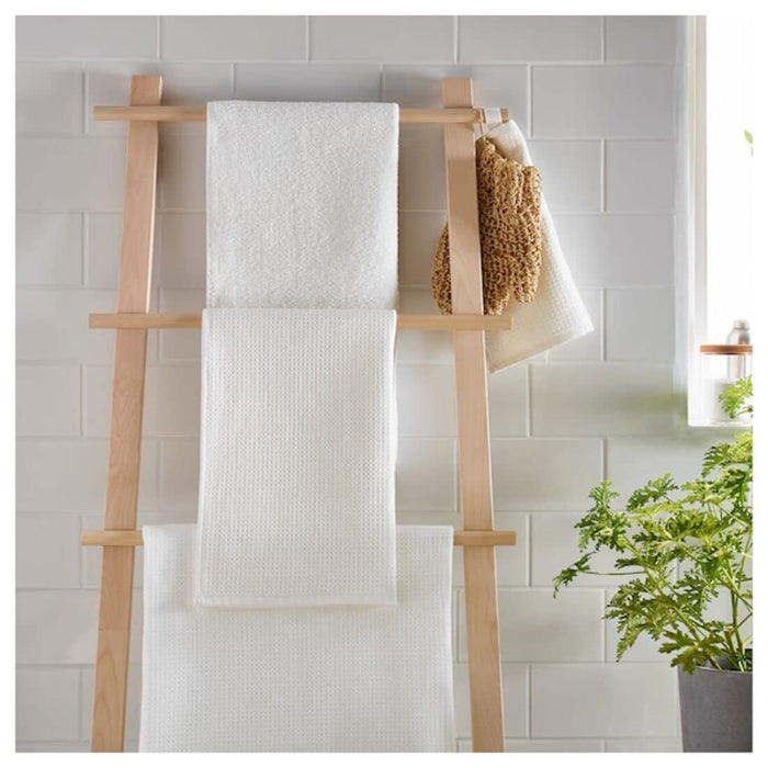 A folded Ikea hand towel in White color was placed on a wooden shelf