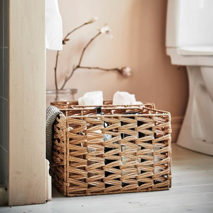 A woven basket made from natural fibers, perfect for storing blankets or pillows in a cozy living room.
