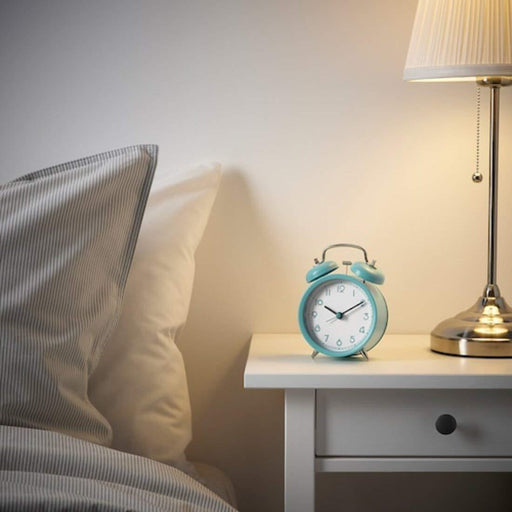 IKEA PLIRA turquoise alarm clock styled on bedside table with striped pillow and table lamp
