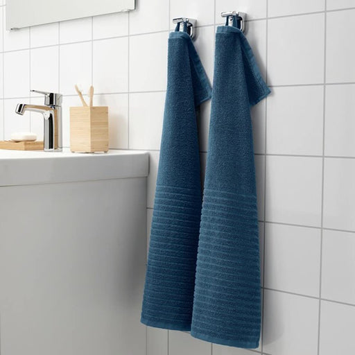 A close-up image of a simple and classic dark blue hand towel hanging on a bathroom hook 50488055