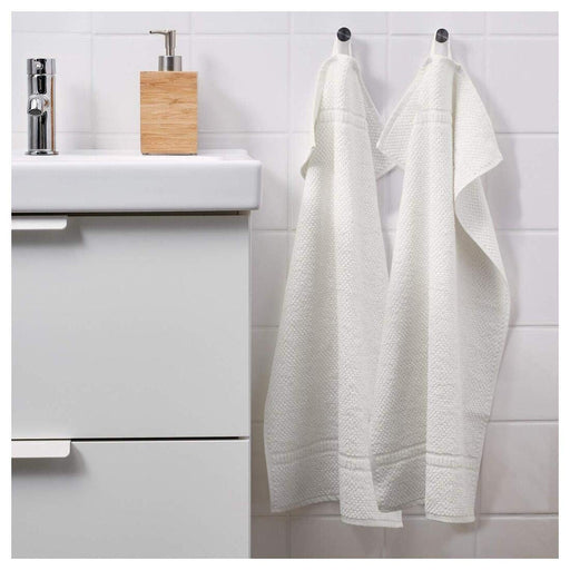 An image of a white  hand towel hanging from a hook on a bathroom wall 70168468