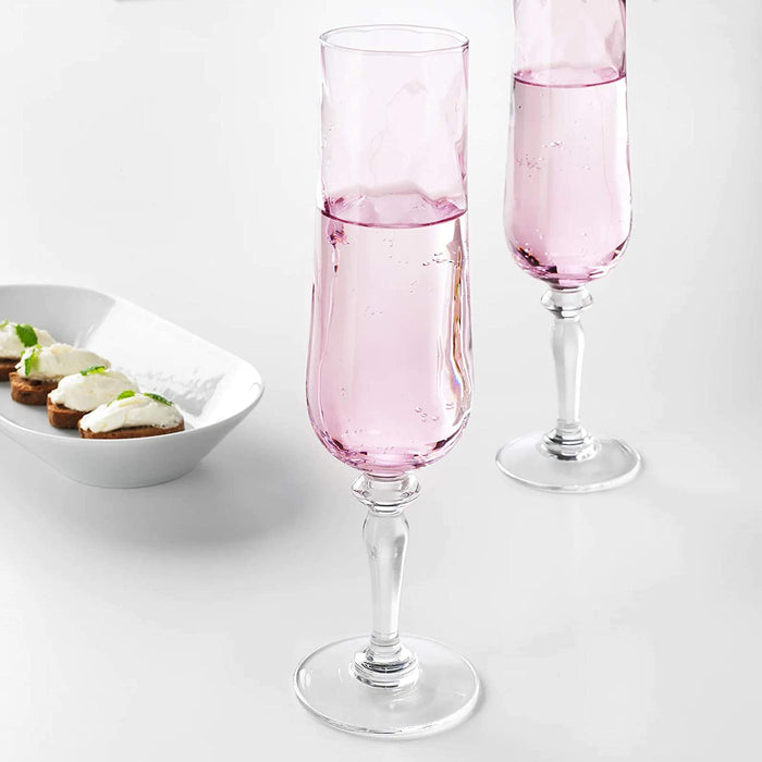A classic IKEA champagne glass made from clear glass, with a long stem and a narrow, tapered bowl