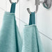 A close-up image of a folded Turquoise hand towel with a textured pattern 30512872