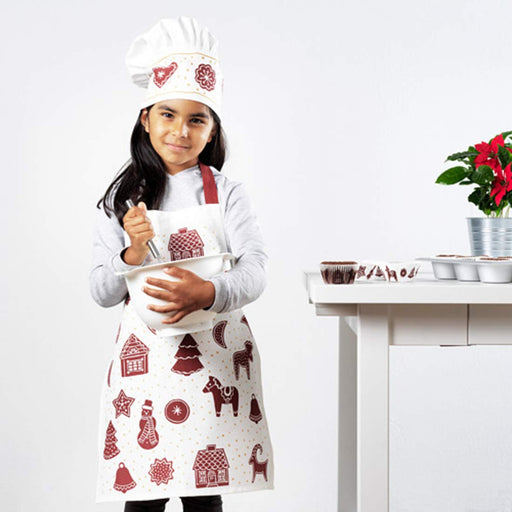 Child wearing a colorful chef hat from Ikea while holding a cooking utensil 10472419