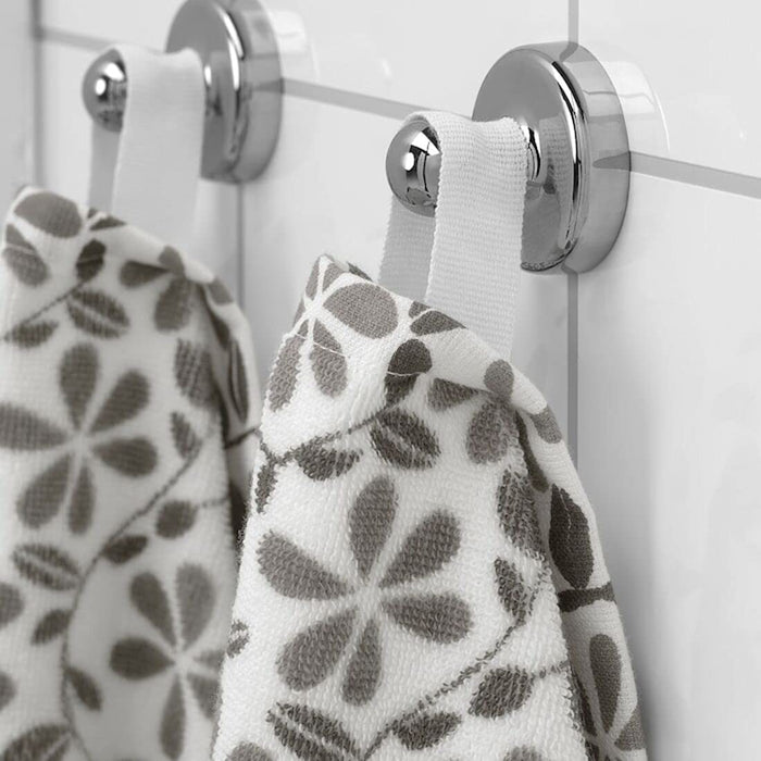 A close-up image of a simple and classic white/pink hand towel hanging on a bathroom hook 70455596