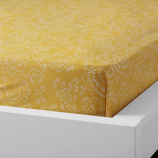 Yellow cotton flat sheet and pillowcase from IKEA draped on a bed  10418979