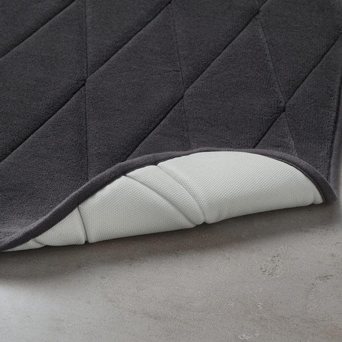 An IKEA bath mat with a pebble-like texture in a calming seafoam
