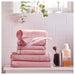 A pink IKEA hand towel a It is folded neatly and placed on a wooden surface 10405236