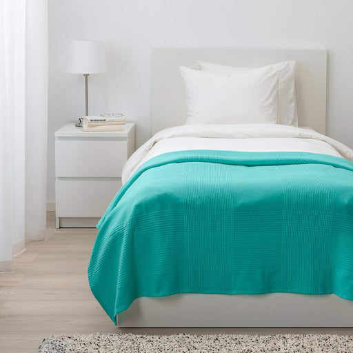 bedspread with coordinating decorative pillows, spread across a crisp white bed.-70459561 