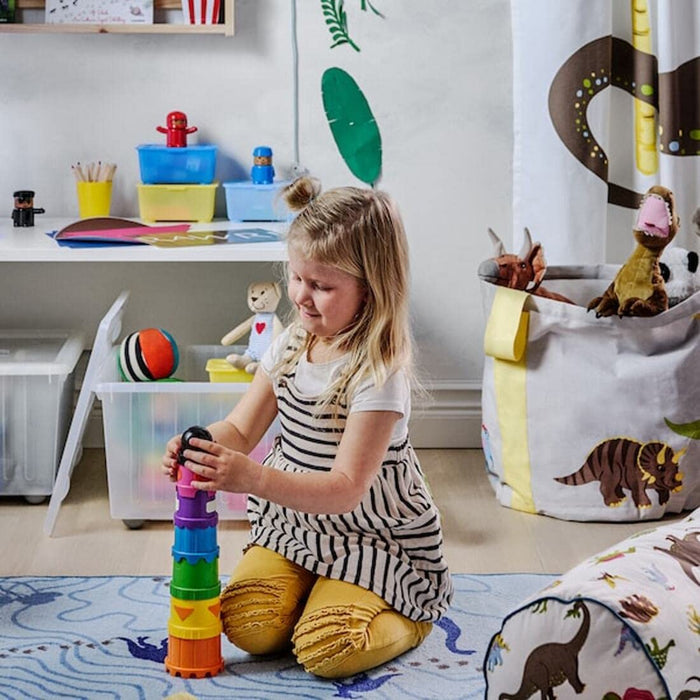 A girl  building a tower using different colored beakers from IKEA's collection. 40294878
