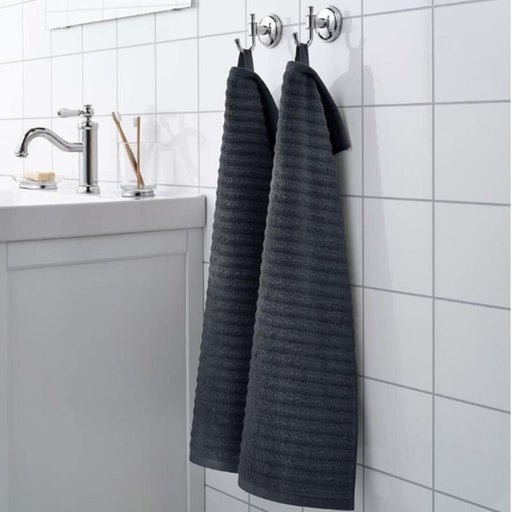 A grey Ikea hand towel with fringed edges hanging on a hook. 70468706