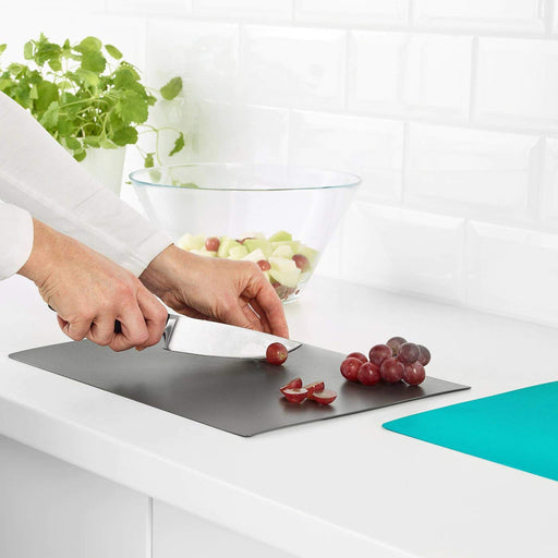 A round plastic cutting board with a non-slip base, suitable for chopping and cutting fruits and vegetables
