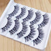 A pair of glamorous false eyelashes on a black background.