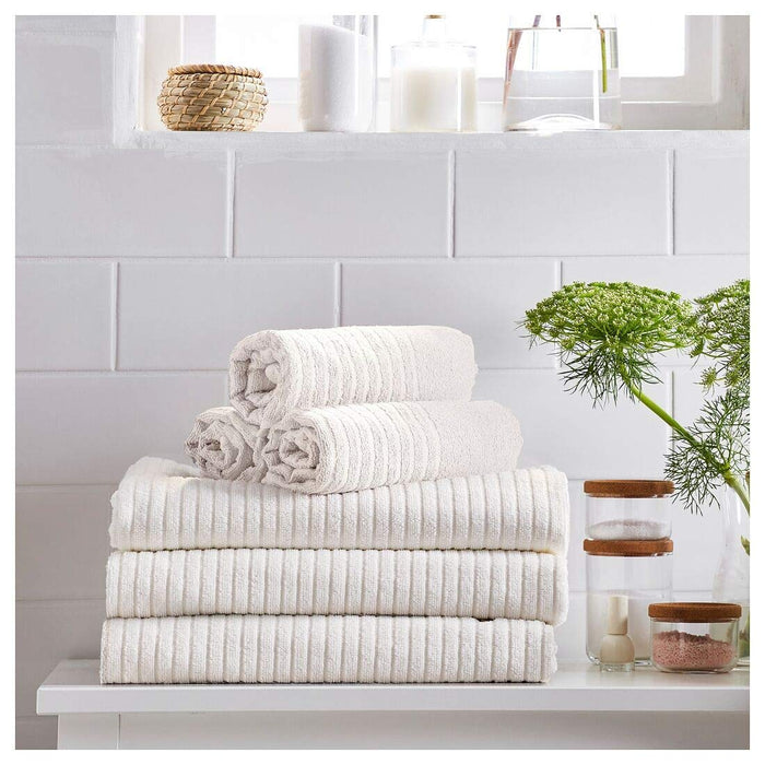 A stack of four white washcloths from the Ikea 6 Piece Combo Set, sitting on a white bathroom counter.
