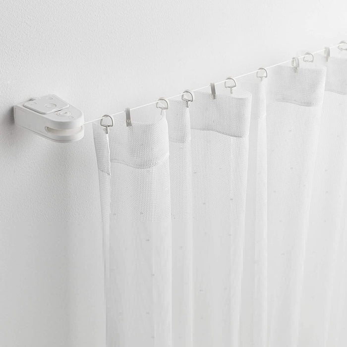  IKEA Curtain Wire in White being used as a room divider, with a plant and a chair in the background.