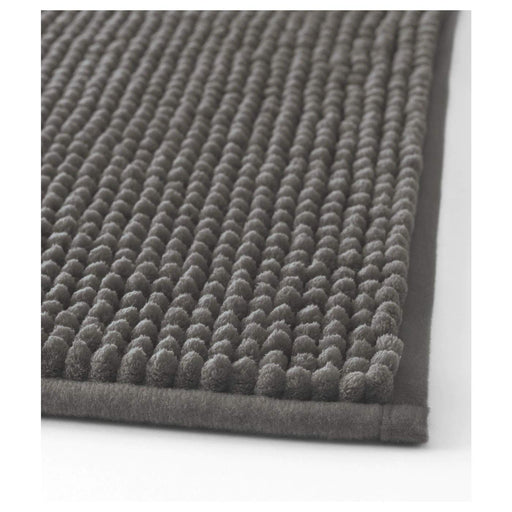Grey IKEA bath mat placed on a bathroom floor, featuring a soft and absorbent texture and a non-slip bottom for secure footing 50278873