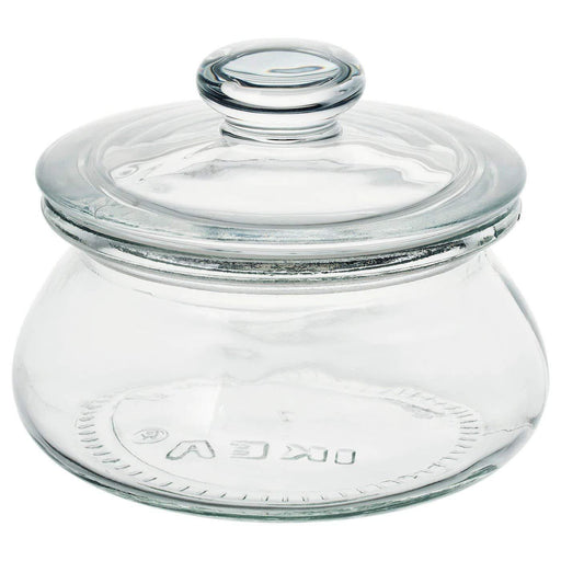 A clear glass jar with a lid on top, used for storage or organization.
