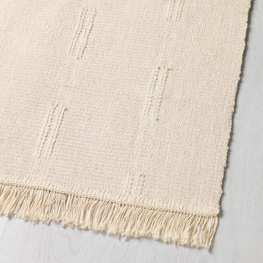  IKEA SORTSÖ beige cotton rug neatly folded showing flat weave texture and light fringe edges