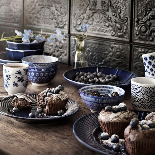 IKEA ENTUSIASM blue and white patterned bowl and mug set styled on wooden table with blueberries and muffins