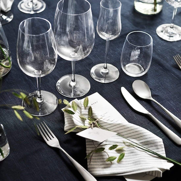  set of four IKEA red wine glasses arranged on a tabletop, featuring a clear glass design with a graceful, tapered stem and a wide bowl that lets the wine breathe and aerate.