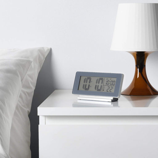 A digital alarm clock with a large snooze button