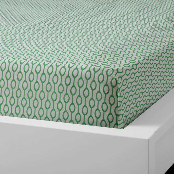 Green cotton flat sheet and pillowcase from IKEA draped on a bed  10419083