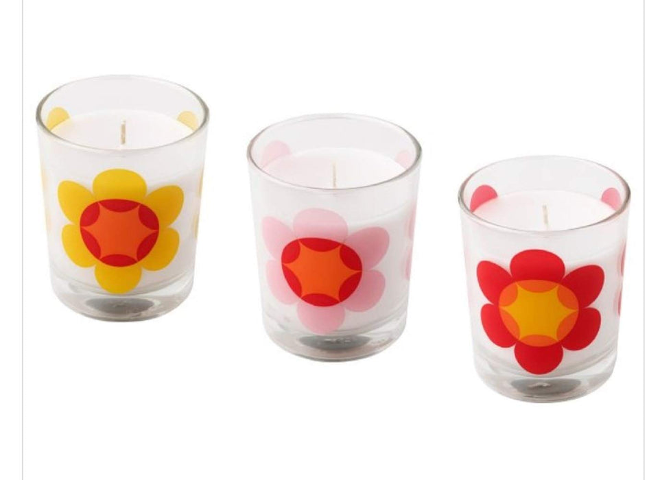 A clear glass votive candleholder with a white unscented candle.