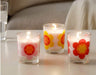 A round glass tealight candleholder with a white unscented candle.