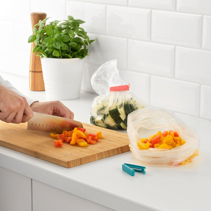 An IKEA sealing clip attached to a plastic cover, creating an airtight seal around a dish of food 90339172