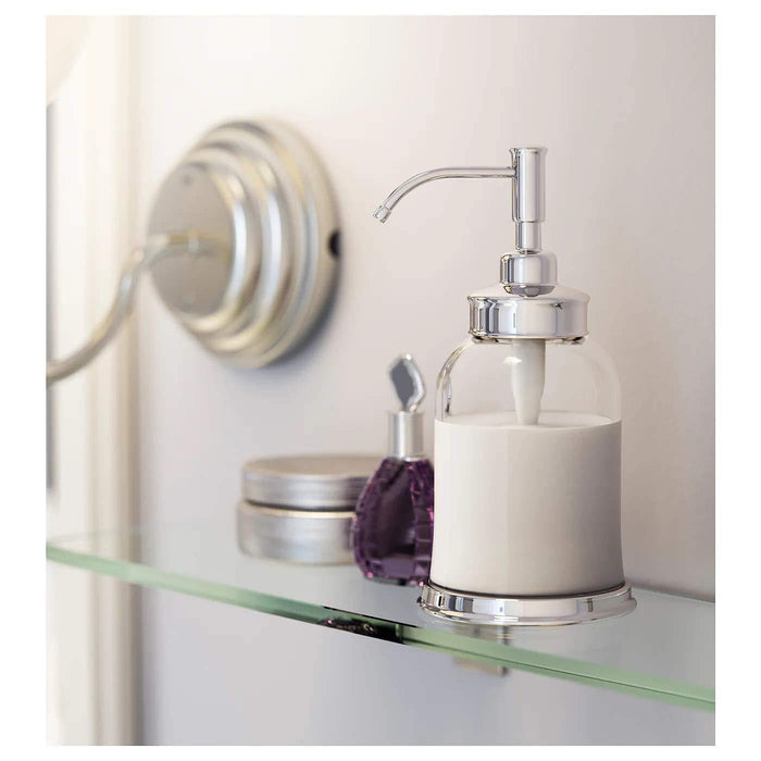 An IKEA soap dispenser with a transparent glass container and a polished chrome pump, designed to dispense liquid soap with ease.