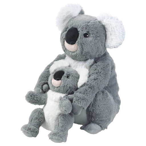 A child holding the IKEA Soft Toy Koala in their arms, with a big smile on their face.