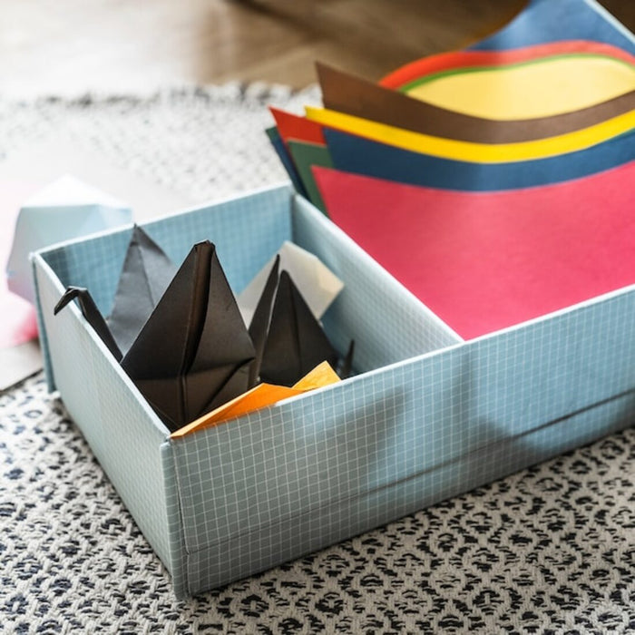 A blue box with multiple compartments designed for storing crafting materials, featuring a colorful design and several compartments to accommodate various papers 60493914