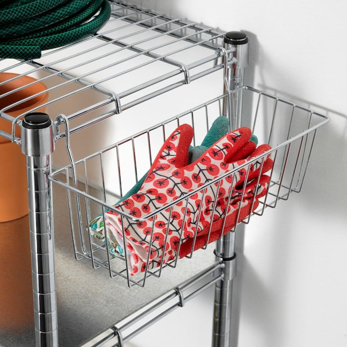 IKEA clip-on basket in a bedroom, holding folded clothes