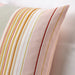 A close-up of an IKEA pink cushion cover with a multicolor/striped pattern on a white background-20513631