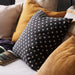 Multiple IKEA cushion covers in different colors and designs on a bed-10474705