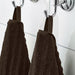  A close-up image of a simple and classic dark brown hand towel hanging on a bathroom hook 80469140