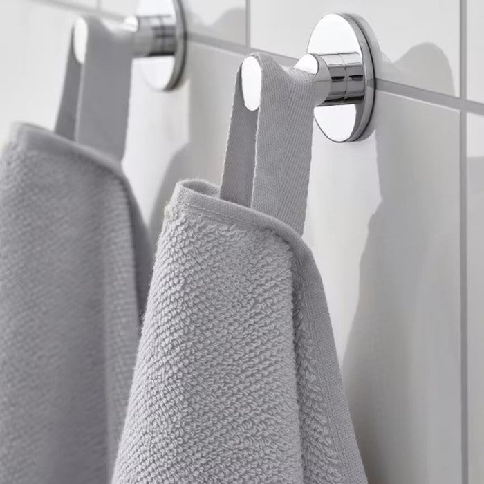 A close-up image of a folded Light grey hand towel with a textured pattern 90521232 